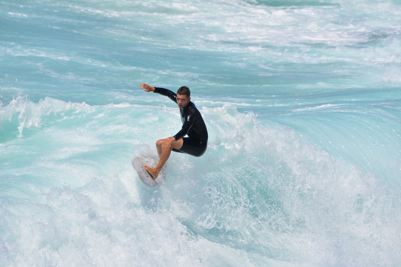 A surfer carving across a breaking wave