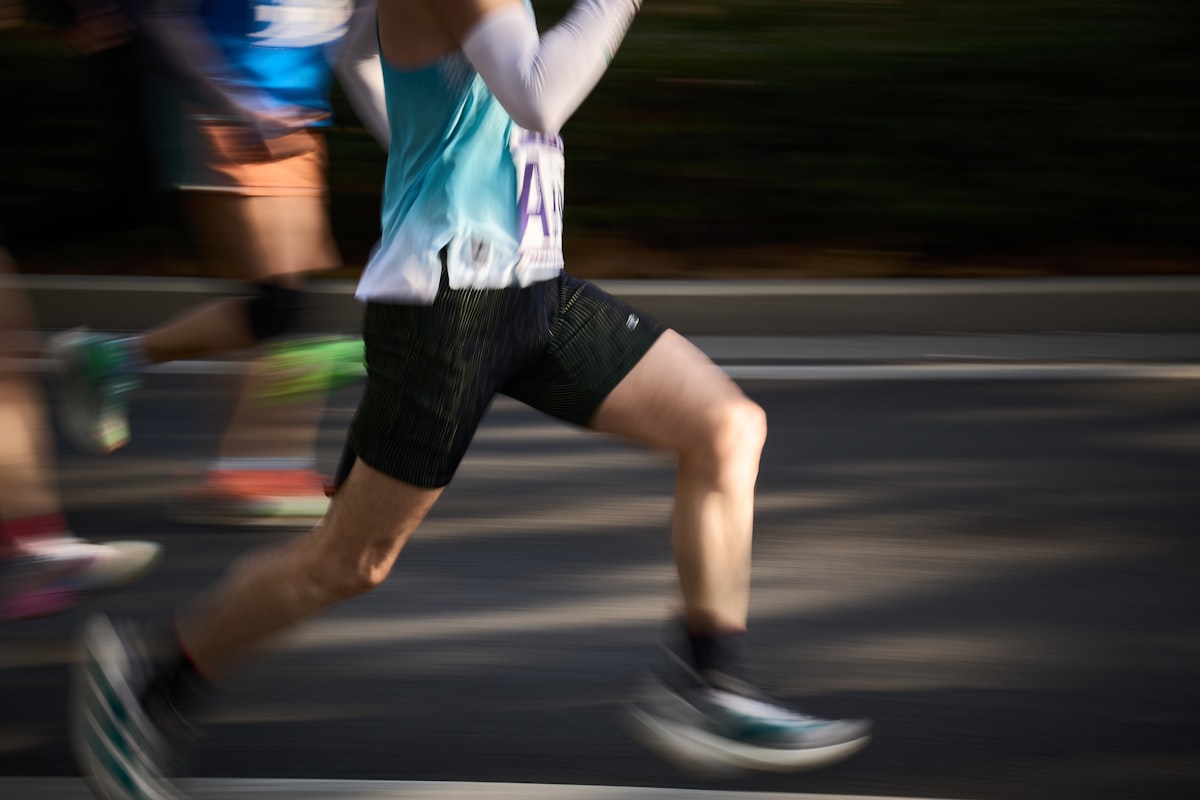 A runner in full stride, with the race moving behind them